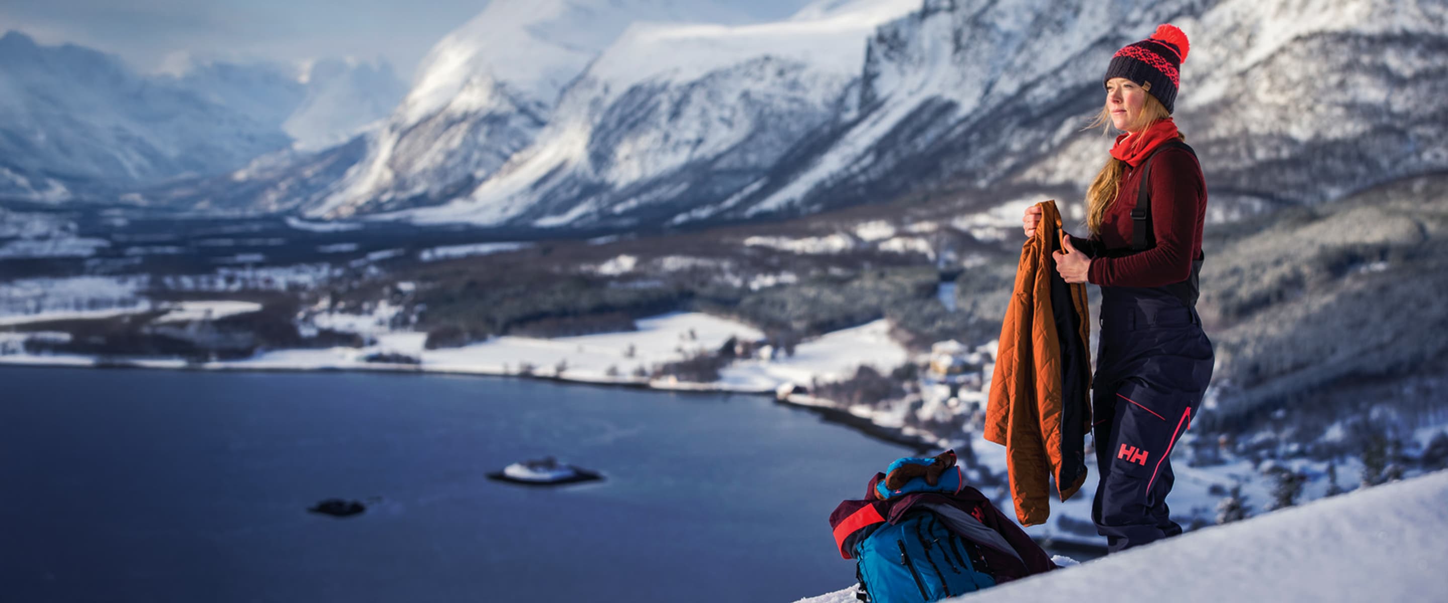 Kobieta ubrana w odzież outdoorową w górach na tle skandynawskiego pejzażu